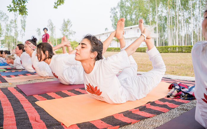 Arhanta yoga students bend in Bow Pose on a Yoga Teacher Training in India